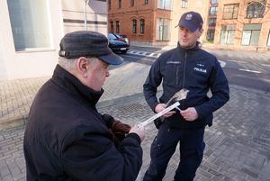 Na zdjęciu starszy mężczyzna otrzymał od policjanta odblask.