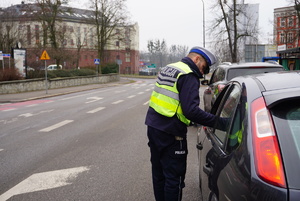 Na zdjęciu policjant ruchu drogowego wręcza mandat karny kierującej.