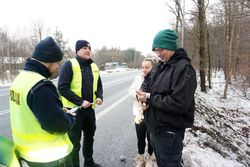 Na zdjęciu policjanci rozdają pieszym odblaski.