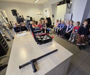 Na zdjęciu technik kryminalistyki podczas prelekcji z dziećmi na temat bezpieczeństwa.