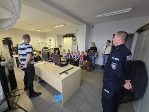 Na zdjęciu policyjny profilaktyk opowiada dzieciom o bezpieczeństwie.