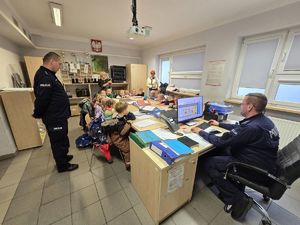 Na zdjęciu maluszki z przedszkola uważnie słuchają o służbie w Policji.