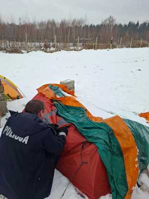 Policjant kontroluje miejsce przebywania osób bezdomnych.
