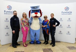 Na zdjęciu Sznupek, Pani Prezes Fundacji, Dyrektor Przedszkola oraz policjanci.