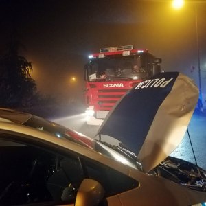 uszkodzony radiowóz i w oddali wóz strażacki