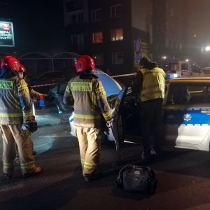 strażacy i technik kryminalistyczny przy uszkodzonym pojeździe