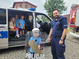 na zdjęciu policjant z dzieckiem przy radiowozie
