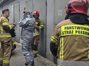 na zdjęciu strażacy ubierają specjalistyczne kombinezony