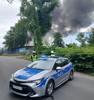 na zdjęciu radiowóz w tle pożar