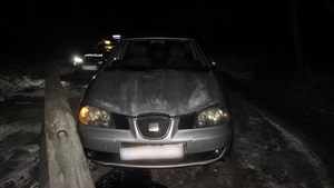 Na zdjęciu widnieje pojazd marki Seat, a w jego tle radiowóz policyjny