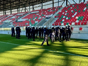 Zdjęcie przedstawia grupę umundurowanych policjantów znajdujących się na terenie obiektu podczas ćwiczeń.