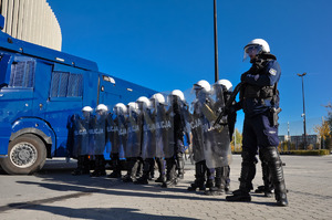 Zdjęcie przedstawia policjantów przy armatce wodnej.