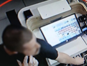 Zdjęcie przedstawia mężczyznę wyciągającego z kasetki pieniądze.