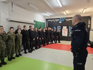 Zdjęcie przedstawia uczniów klas mundurowych podczas zajęć z instruktorem.