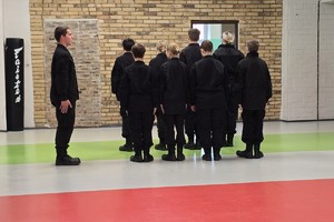 Zdjęcie przedstawia uczniów klas mundurowych podczas zajęć z instruktorem.