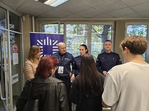 Zdjęcie przedstawia umundurowanych policjantów rozmawiających z uczestnikami wydarzenia.
