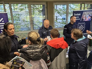 Zdjęcie przedstawia umundurowanych policjantów rozmawiających z uczestnikami wydarzenia.