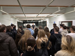 Zdjęcie przedstawia policyjnego instruktora oraz studentów na strzelnicy.