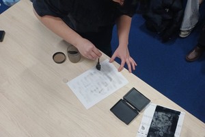 Zdjęcie przedstawia policjanta z wydziału ruchu drogowego prezentującego sprzęt służbowy.