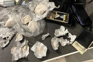 Zdjęcie przedstawia zabezpieczone substancje w folii aluminiowej leżące na stole.