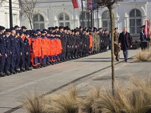 Zdjęcie przedstawia uczestników uroczystości na placu Dworca PKP.