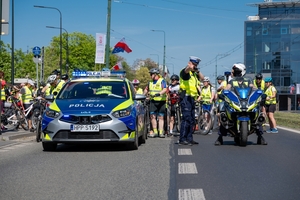 Zdjęcie przedstawia umundurowanych policjantów oraz radiowóz i motocykl policyjny