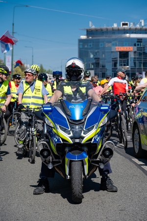 Zdjęcie przedstawia umundurowanego policjanta i motocykl policyjny
