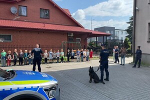 Policjanci, pies służbowy oraz dzieci.