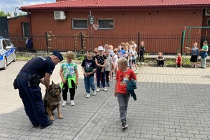 Policjant, pies służbowy oraz dzieci.