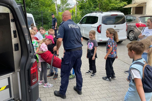 Policjanci, dzieci i radiowóz.