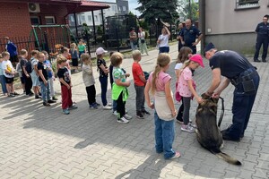 Policjanci, pies służbowy oraz dzieci.