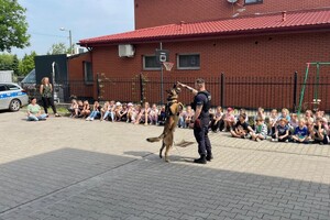 Policjanci, pies służbowy oraz dzieci.