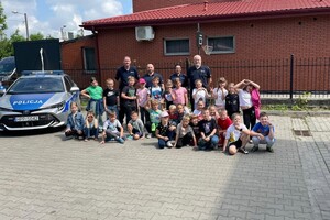 Policjanci i dzieci pozujący do zdjęcia.