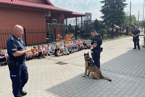Policjanci, pies służbowy oraz dzieci.