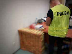 policjant z PG w trakcie prowadzenia oględzin zabezpieczonych papierosów