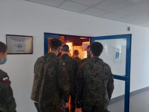 Na zdjęciu widać umundurowanych licealistów z klasy mundurowej w trakcie wchodzenia do pomieszczenia Izby Pamięci zalokalizowanej w siedzibie KWP Katowice