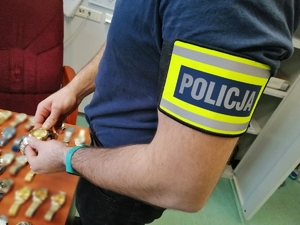 policjant przed biurkiem z zegarkami
