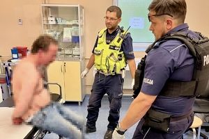 na zdjęciu policjanci pilnują zatrzymanego podczas wizyty w szpitalu