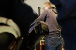 zdjęcie przedstawia: nieumundurowanego policjanta pobierającego odciski palców zatrzymanemu mężczyźnie