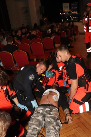 zdjęcie przedstawia: policjantów oraz medyków podczas udzielania pierwszej pomocy