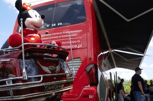 zdjęcie przedstawia: zbliżenie na motocykl a w tle autobus honorowego oddawania krwi
