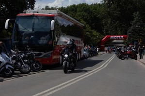 zdjęcie przedstawia: przejeżdżający motocykl a w tle autobus do oddawana krwi