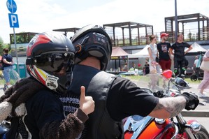 zdjęcie przedstawia: motocyklistę wraz z pasażerem pokazujący symbol &quot;OK&quot;