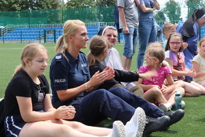 zdjęcie przedstawia: policjantkę siedzącą z dziećmi