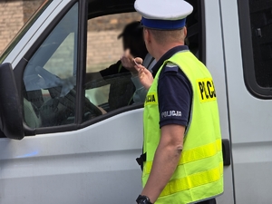 zdjęcie przedstawia policjanta podczas kontroli drogowej