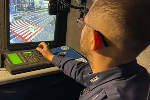 zdjęcie przedstawia policjanta podczas obserwacji monitoringu