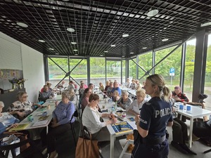zdjęcie przedstawia policjantkę rozmawiającą z mieszkańcami