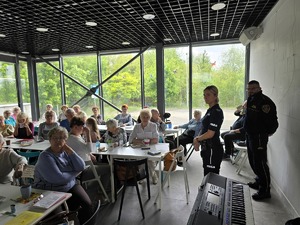 zdjęcie przedstawia strażnika miejskiego i policjantkę rozmawiającą z mieszkańcami