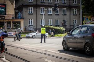 zdjęcie przedstawia policjanta zabezpieczającego przejazd motocykli