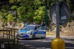 zdjęcie przedstawia policjanta zabezpieczającego przejazd motocykli
